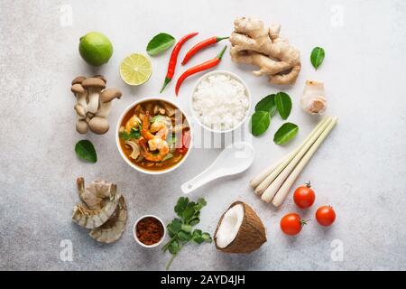 Tom Yum Goong o Tom Yam Kung e set di ingredienti per cucinare. Tradizionale zuppa tailandese di gamberi speziati con latte di cocco. Disposizione piatta. Foto Stock