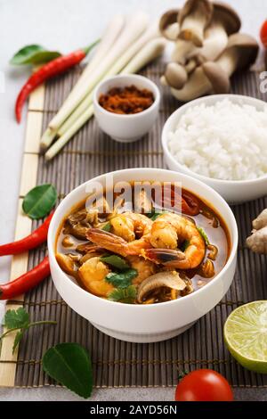 Tom Yum Goong zuppa tailandese piccante con gamberi, latte di cocco e funghi. Tom Yum Kung servito con riso. Cucina tradizionale tailandese. Foto Stock