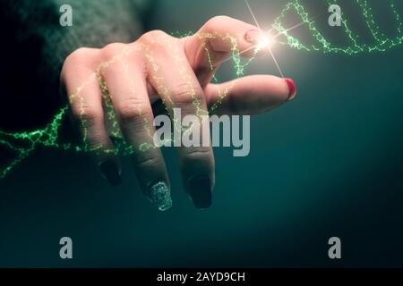 Primo piano della donna Che Tocca la molecola di DNA verde. Supporti misti. Foto Stock