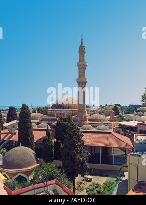 Vista panoramica della città di rodi con la cupola e il minareto della moschea del Suleiman e gli edifici della città contro un cielo blu estivo Foto Stock