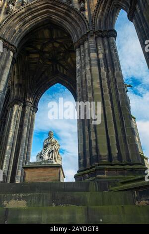 Vista dello skyline attraverso il monumento Scott, dedicato all'autore Sir Walter Scott sui Princess Street Gardens. Foto Stock