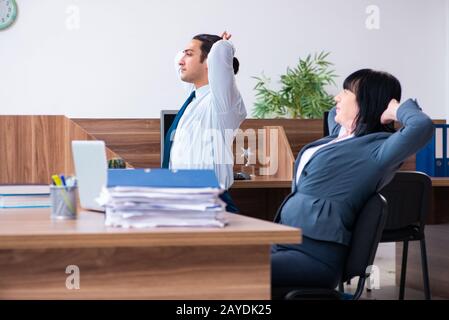 Due dipendenti facendo sport esercizi in ufficio Foto Stock