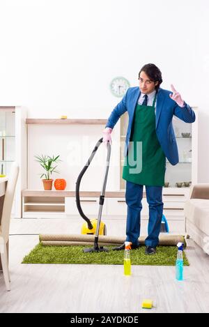 Giovane uomo d'affari che pulisce la casa Foto Stock