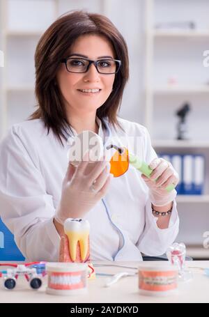 Donna dentista lavora sui denti impianto Foto Stock