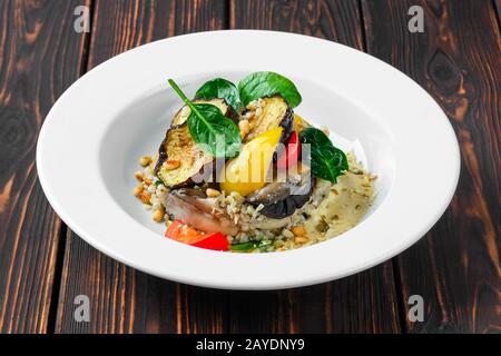 Melanzane arrosto con peperone, grano saraceno verde, pinoli e semi di zucca Foto Stock