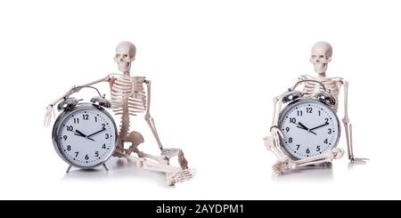 Lo scheletro con la sveglia sul bianco Foto Stock