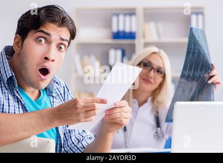 Paziente maschio arrabbiato con costosi healthcare bill Foto Stock