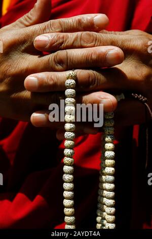 Mano di monaco che tiene il rosario buddista-mala-nenju Foto Stock