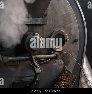 Chicco di caffè tostatore a lavorare in una sala di produzione Foto Stock