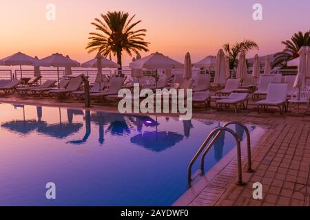 Piscina sull'isola di Cipro al tramonto Foto Stock