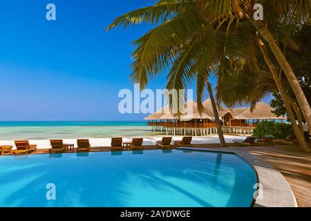 La piscina e il bar sulla spiaggia delle Maldive Foto Stock