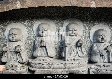 Sculture buddiste scolpite su un muro del tempio nel monastero di Wenshu Foto Stock