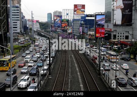 Mandaluyong City, Filippine - 13 febbraio 2020: Percorsi ferroviari vuoti su una strada principale congestionata a Metro Manila. Foto Stock