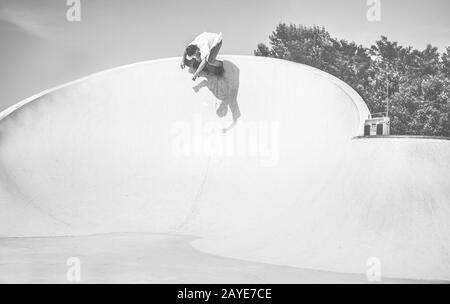 Skater che si esibisce nella rampa del skate Park - skateboard da giovane uomo in città - Sport estremi, giovani e stile di vita alla moda di z generation - Focus on h Foto Stock