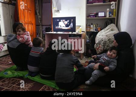 Una famiglia palestinese guarda la TV a casa propria durante il discorso del presidente palestinese Mahmoud Abbas all'Assemblea generale dell'ONU, nella striscia di Gaza, Foto Stock