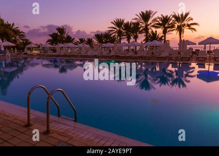 Piscina sull'isola di Cipro al tramonto Foto Stock