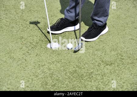 Ragazzo a giocare a minigolf in giorno di estate Foto Stock