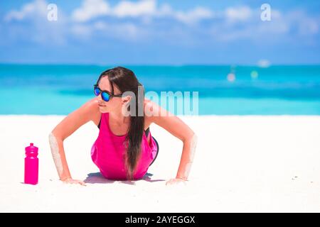 Montare la giovane donna tropicale sulla spiaggia bianca nel suo abbigliamento sportivo Foto Stock