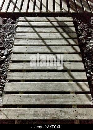 Il lungomare è adagiato su una spiaggia di ciottoli con ombre. Foto Stock