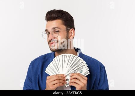 Attraente l uomo è in possesso di denaro contante in una mano, isolato su sfondo bianco Foto Stock