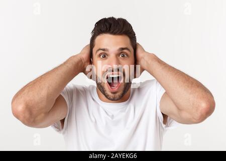Ritratto di giovane uomo con sconvolto l'espressione del viso, isolato su sfondo bianco. Foto Stock