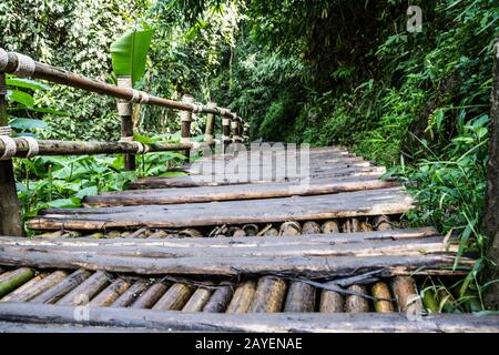 Cattivo ponte di legno nel mezzo della giungla nel nord della Thailandia Foto Stock