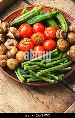 Verdure grigliate assortite. Funghi, pomodori, fagioli e vigna cucinati alla griglia. Foto Stock