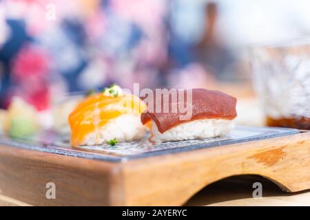 Set di sushi di tonno e salmone servito su una piccola tavola in legno in un ristorante Foto Stock