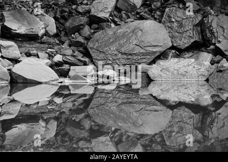 perfetta riflessione di pietre in acqua liscia. Immagine per sfondo, sfondo Foto Stock