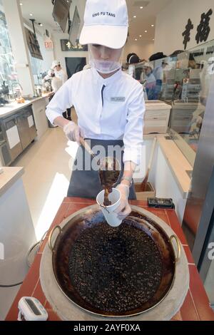 Un giovane Asiatico Americano fa una bevanda di latte di boba nella finestra a Xing fu Tang, un negozio taiwanese a Main St. A Flushing, Queens, Chinatown di New York. Foto Stock