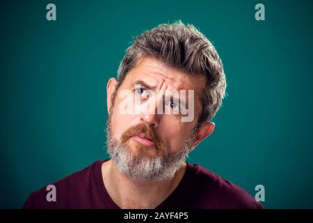 Un ritratto di uomo pensoso bearded in t-shirt rossa. Concetto di persone ed emozioni Foto Stock