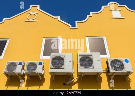 Condizionatori d'aria sulle pareti gialle delle case Foto Stock