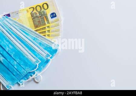 Maschere mediche e banconote da 200 euro come simbolo di un aumento dei prezzi per la protezione del tratto respiratorio dai virus. Ci è un posto per copyspace Foto Stock