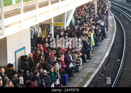 Una piattaforma molto affollata con pendolari che cercano di trovare una camera su un treno per arrivare a Londra Foto Stock