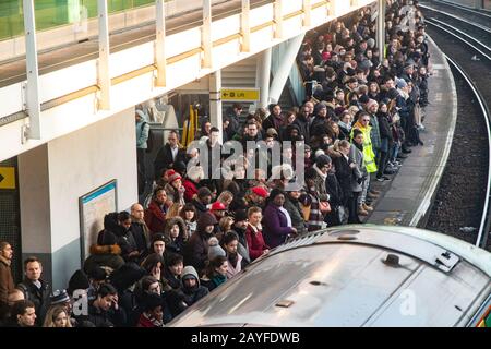 Una piattaforma molto affollata con pendolari che cercano di trovare una camera su un treno per arrivare a Londra Foto Stock