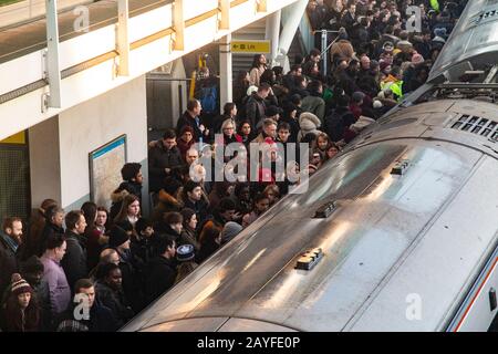 Una piattaforma molto affollata con pendolari che cercano di trovare una camera su un treno per arrivare a Londra Foto Stock