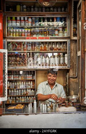 Uomo nel negozio di profumi che mescola fragranze, colorato streetlife sul mercato di Jodhpur, Rajasthan, India Foto Stock