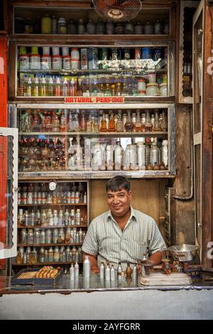 Uomo nel negozio di profumi che mescola fragranze, colorato streetlife sul mercato di Jodhpur, Rajasthan, India Foto Stock