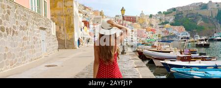 Vacanze in Italia. Vista panoramica banner di bella ragazza in splendido e colorato porto di Procida in Italia. Foto Stock