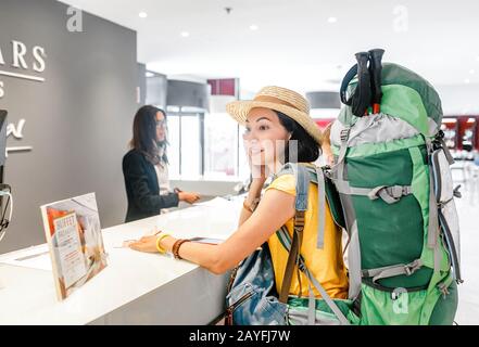 13 LUGLIO 2018, SARAGOZZA, SPAGNA: Felice donna con zaino check-in presso la reception DELL'HOTEL EUROSTARS Foto Stock