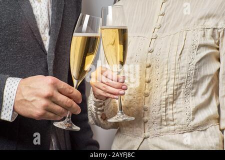 Le mani maschili e femminili tengono bicchieri di champagne. Concetto di celebrazione Foto Stock