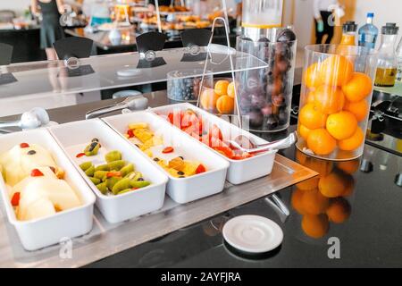 Donna che raccoglie cibo a tutti si può mangiare a buffet a colazione in hotel Foto Stock