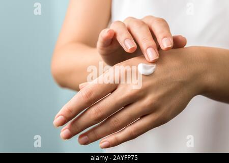mani e chiodi sani. protezione stagionale della pelle. donna che applica moisturizer sulle sue mani Foto Stock