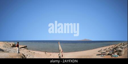 Sharm El Sheikh, Egitto. 24 giugno 2010 panorama della spiaggia in Egitto con vista sul molo e l'isola di Tiran. Le persone si rilassano in vacanza Foto Stock