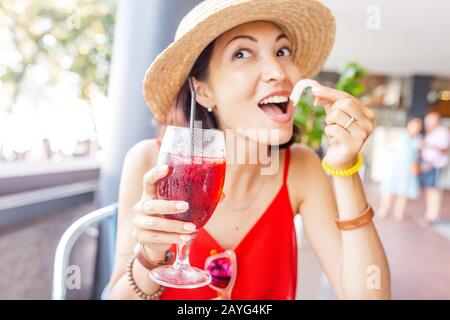 Giovane donna asiatica che beve sangria, tradizionale spagnolo tipo di vino da frutta in ristorante all'aperto Foto Stock