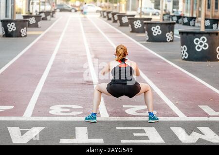 29 LUGLIO 2018, BARCELLONA, SPAGNA: Il giovane corridore della donna fitness si allunga e si riscalda prima di correre in città Foto Stock