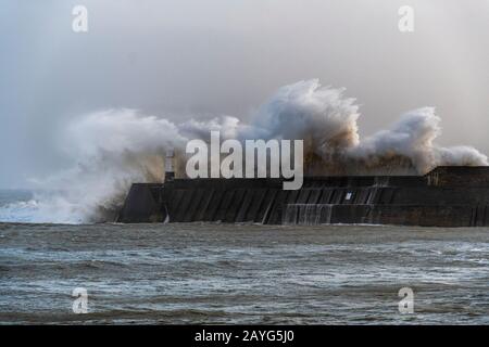 Grandi Onde Storm che si infrangono sul molo di Porthcawl durante la tempesta Ciara Foto Stock
