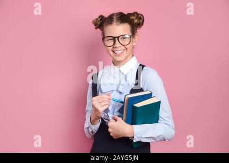 Ragazza sorridente studente in occhiali abbracciando notebook Foto Stock