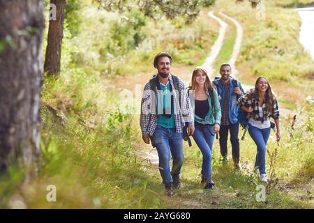 Un gruppo di viaggiatori con zaini è camminare nella natura Foto Stock