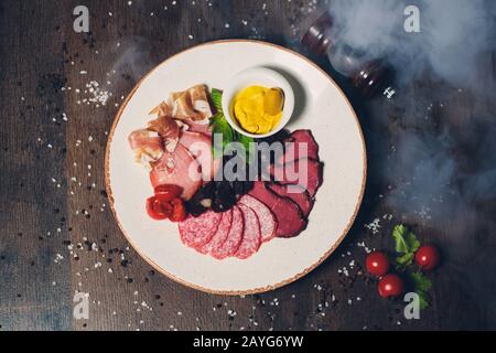 Salame, prosciutto, salsicce, prosciutto e pancetta. Carne Antipasto piatto sul tavolo di pietra. Vista da sopra con lo spazio di copia Foto Stock